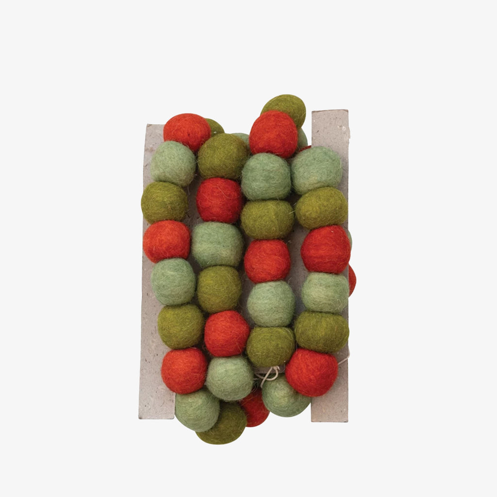 Garland of red and green wool balls on a white background