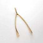 Large Gold Wishbone on a white background at Addison West