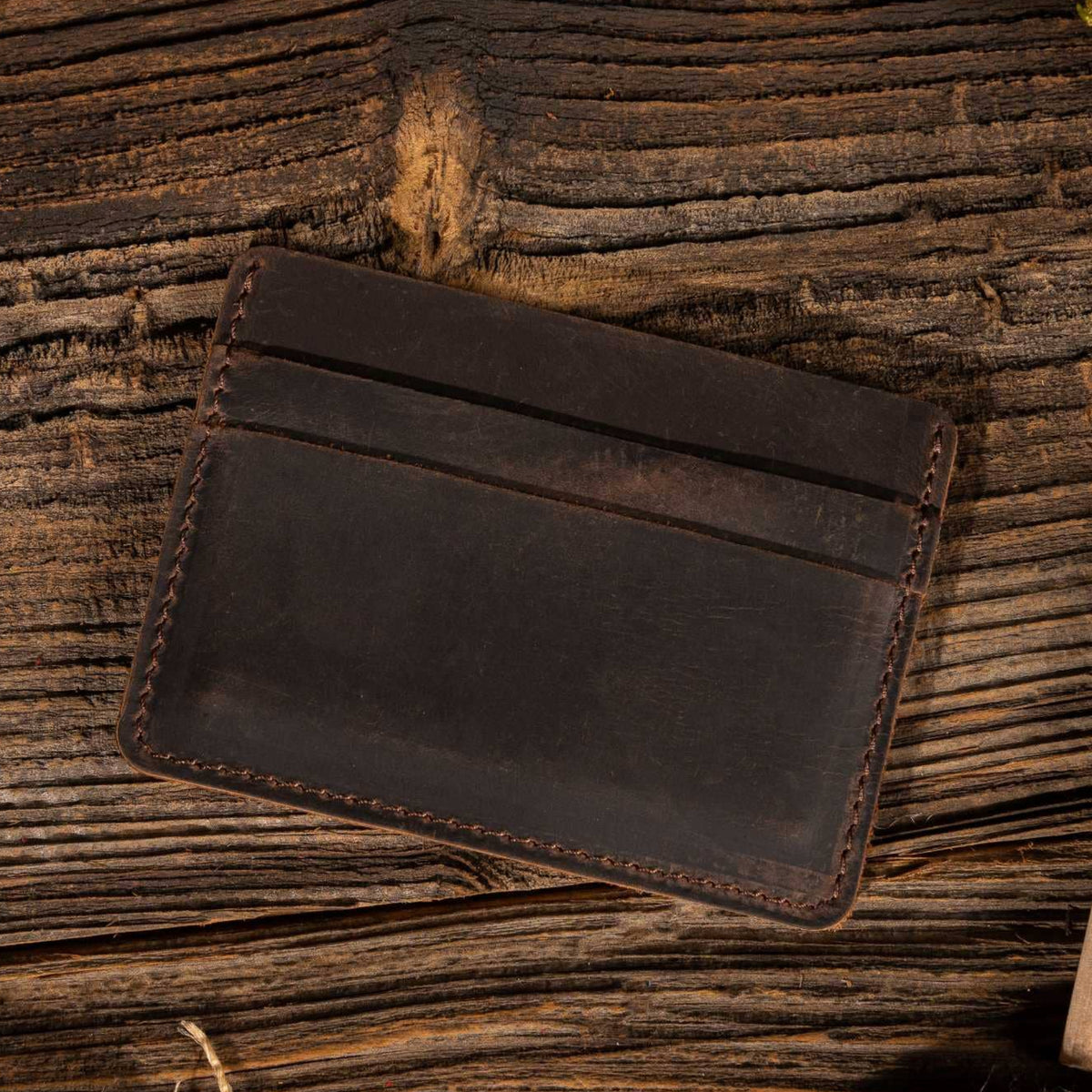 Leather Card Holder Wallet in Dark Brown on a table at Addison West