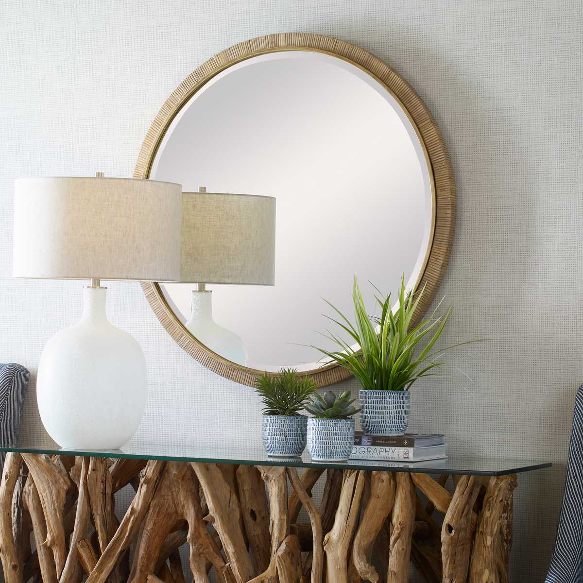 Parnell Round Accent Mirror on a beige wall above a table at Addison West