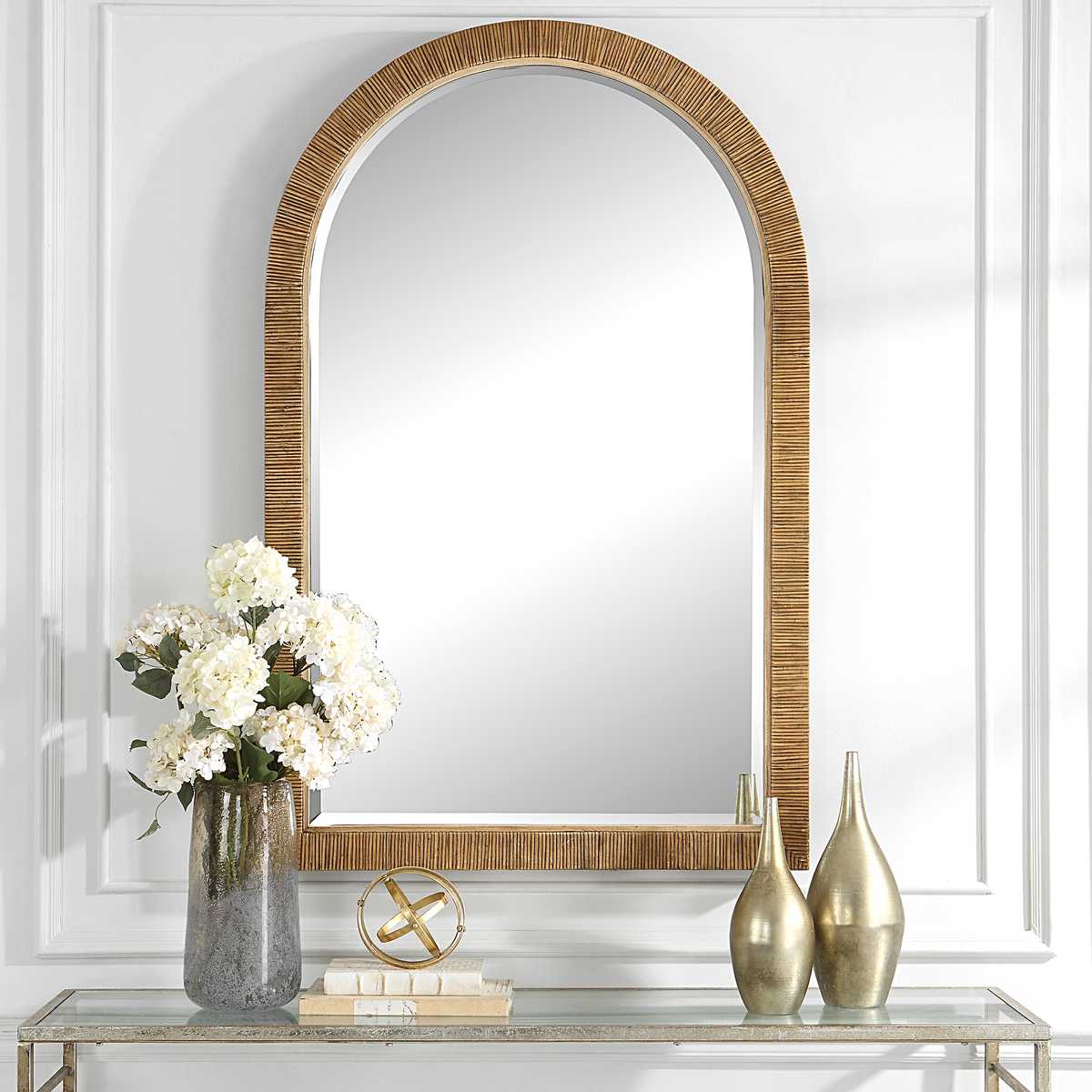 Capridge Arch Accent Mirror on a white wall above a table at Addison West