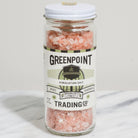 A glass jar of Greenpoint Himalayan Salt with a white lid and a cream-colored label, set on a white marble surface against a light gray background.