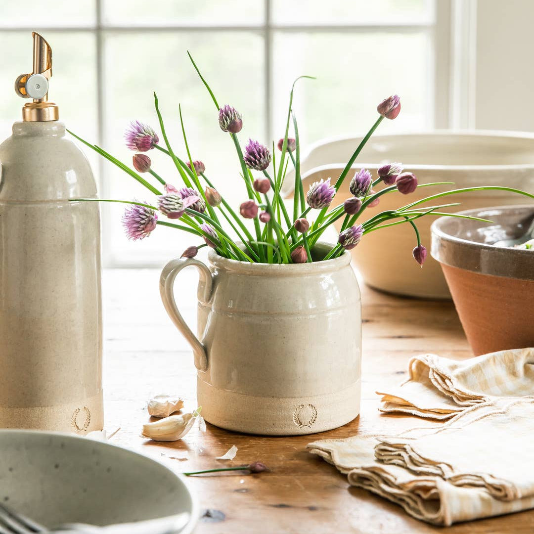 Ceramic pitcher with flowers on a wooden table