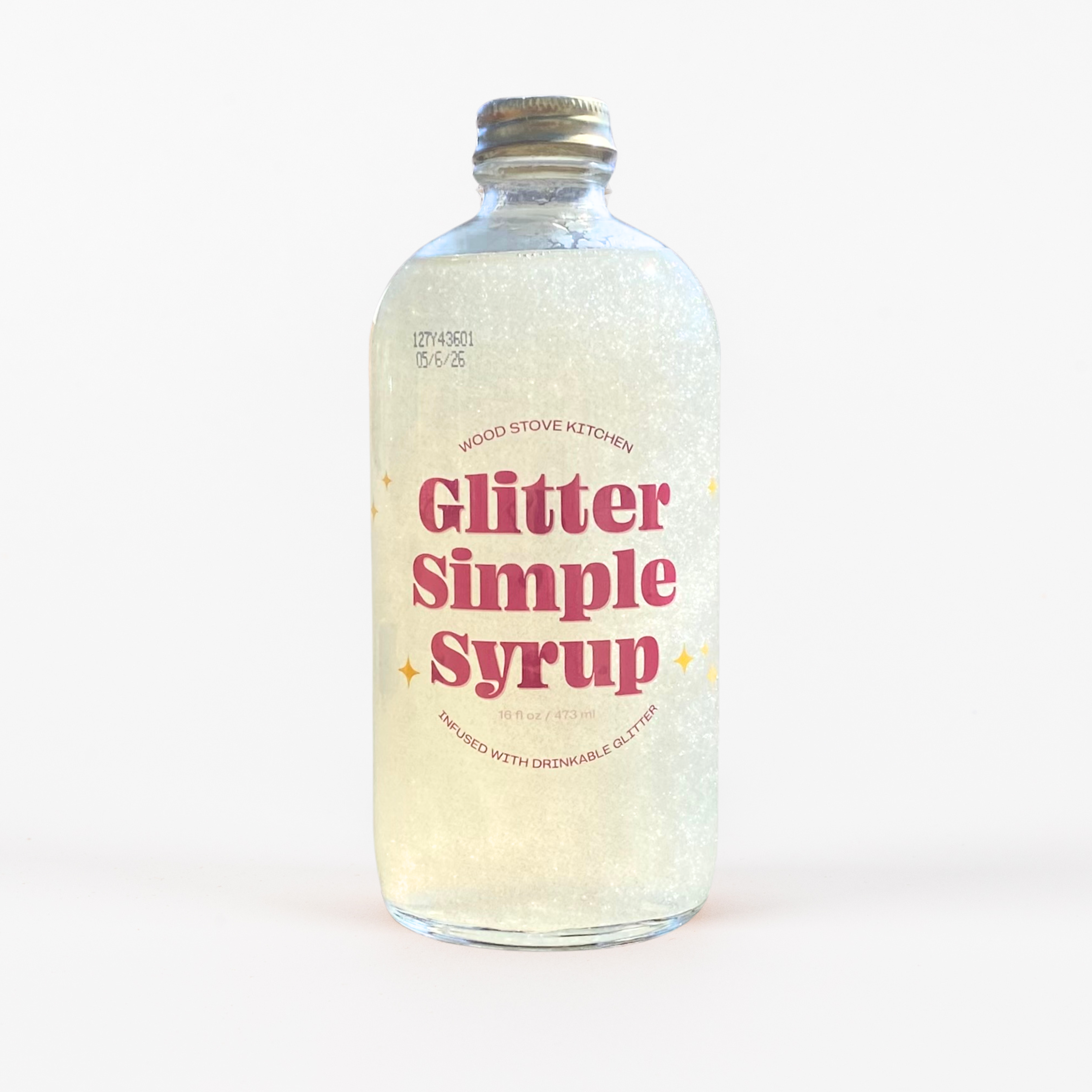 Bottle of 'Glitter Simple Syrup' with a white background