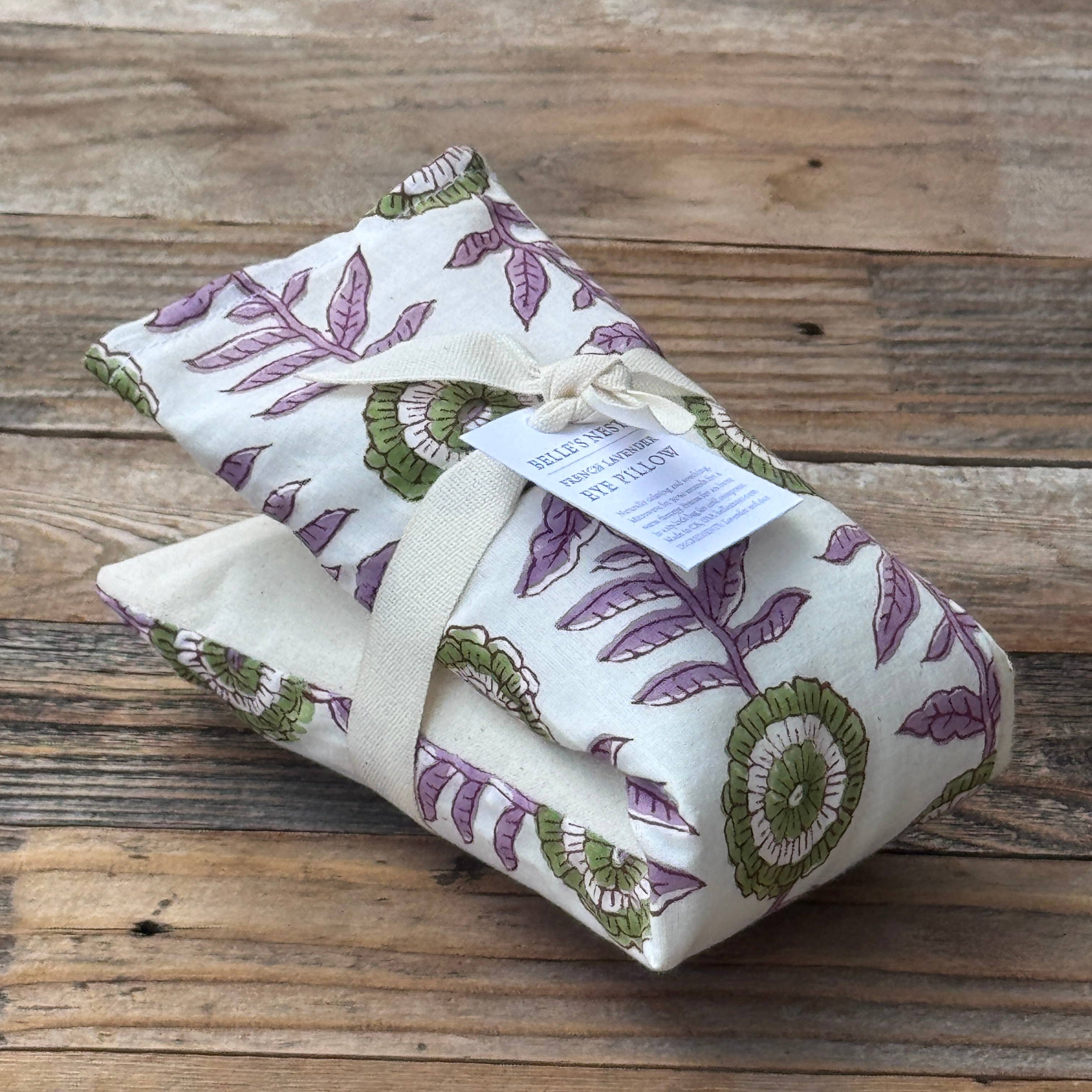 Folded eye pillow with floral pattern on a wooden surface