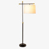 Surya Aberdeen floor lamp with black stand and stem and brass accents and a white linen shade on a white background
