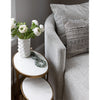 Close up of Four hands brand Farrah chaise with small marble side table and flowers