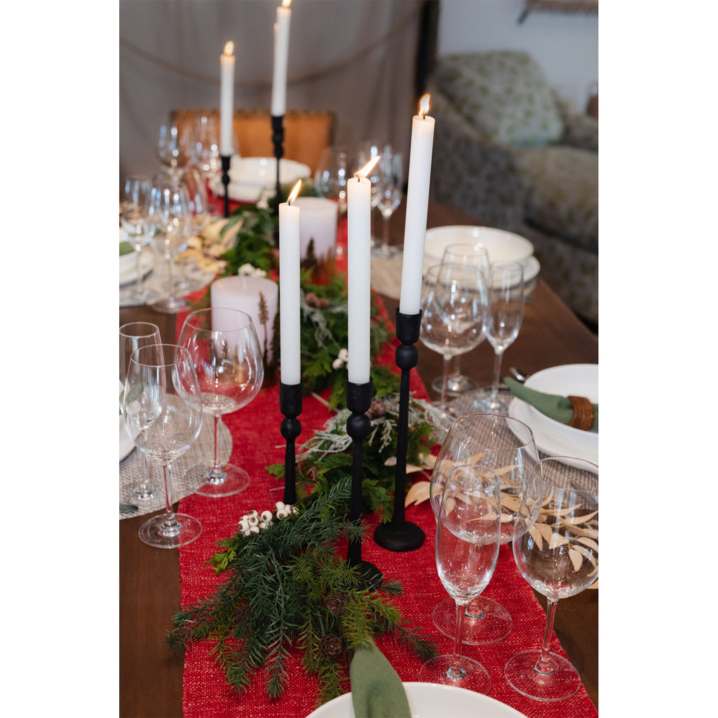 Dining table set with red holiday runner and black cast iron taper candle holders