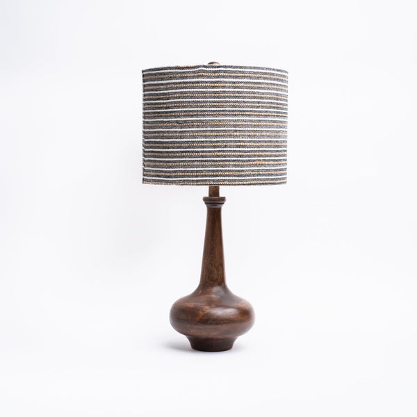 Dark wood curved lamp base with tall neck and striped linen shade on a white background