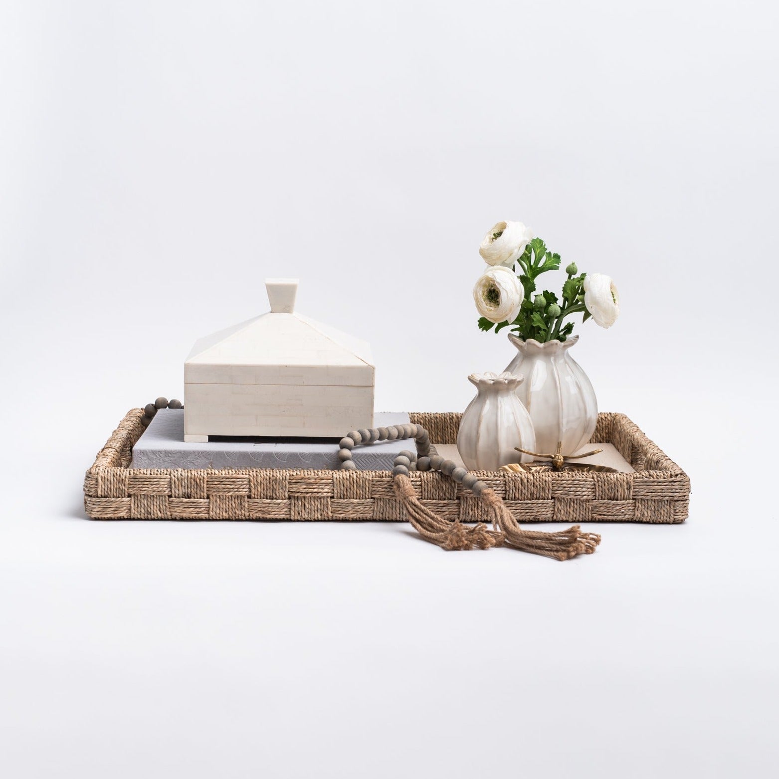 Pyramid Resin Box on a tray with a book beads and a vase with flowers on a white background