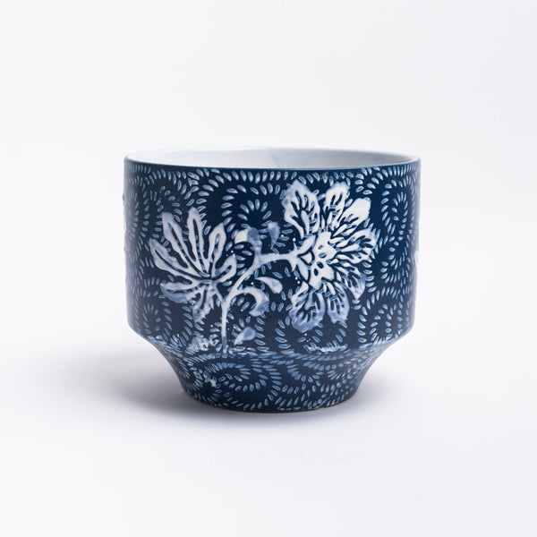 Blue planter with floral pattern on a white background