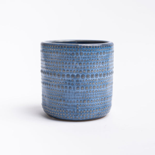 Small blue planter with textured dot pattern on a white background