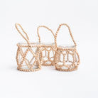 Three glass votive vases wrapped in wood beads with handles on a white background