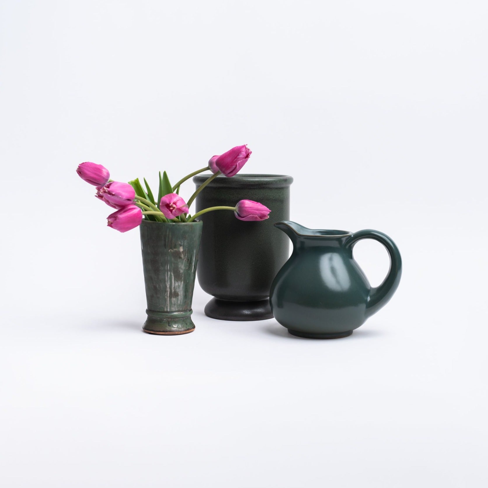 Collection of forest green stoneware pot vase and pitcher on a white background