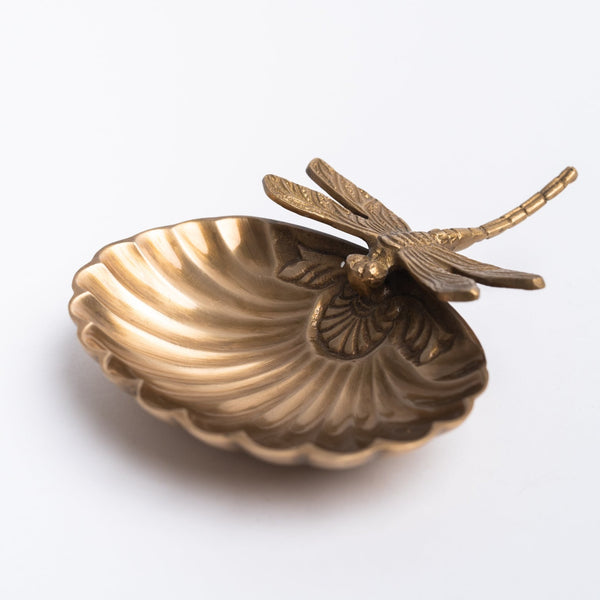Brass scalloped dish with brass cast dragonfly on a white background