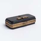 Small black dragonfly box with brass accents on a white background