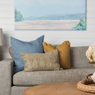 Lina Linen 24" Square Pillow in Arctic Blue, Selena Linen 20" Square Pillow in Desert Yellow, and Nisha Lumbar Pillow in Sage on a beige sofa at Addison West