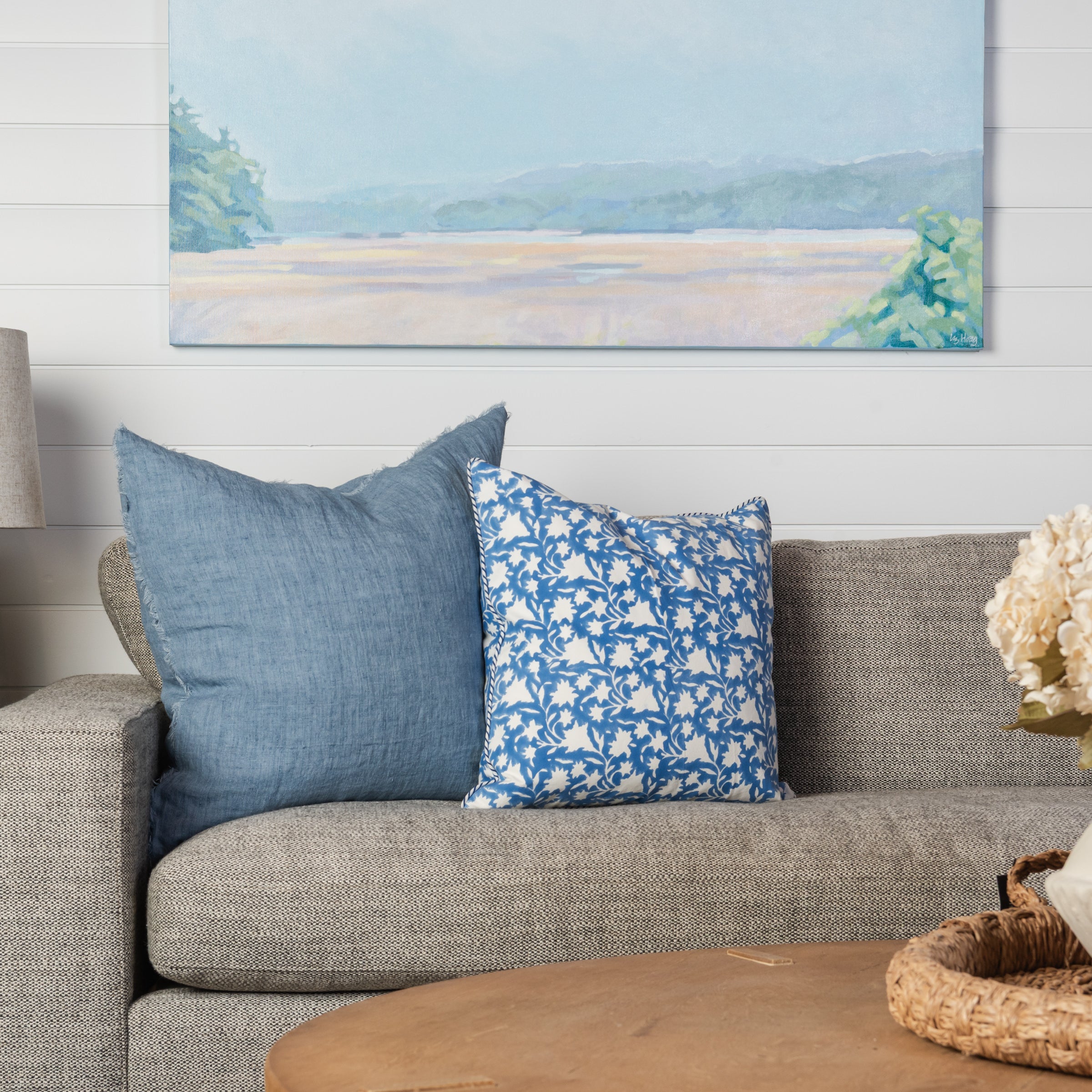 Lina Linen 24" Square Pillow in Arctic Blue and Periwinkle Blockprint 20" Pillow on a beige sofa at Addison West
