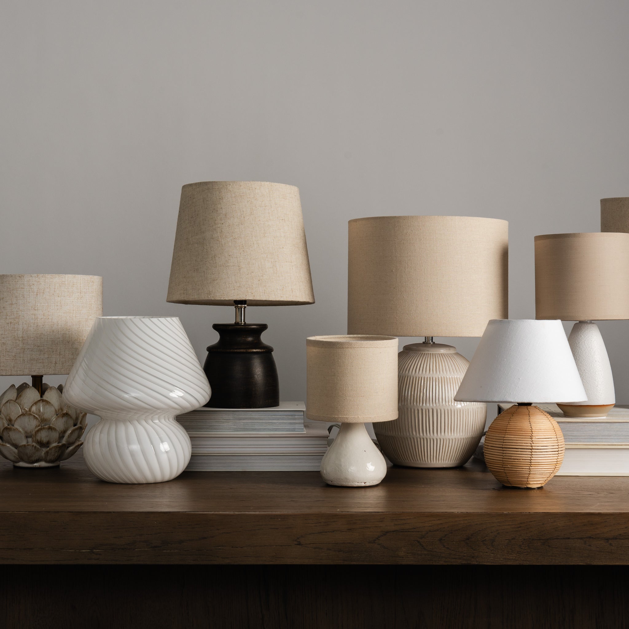 Glassiest Lamp with a collection of mini lamps on a desk and a white background