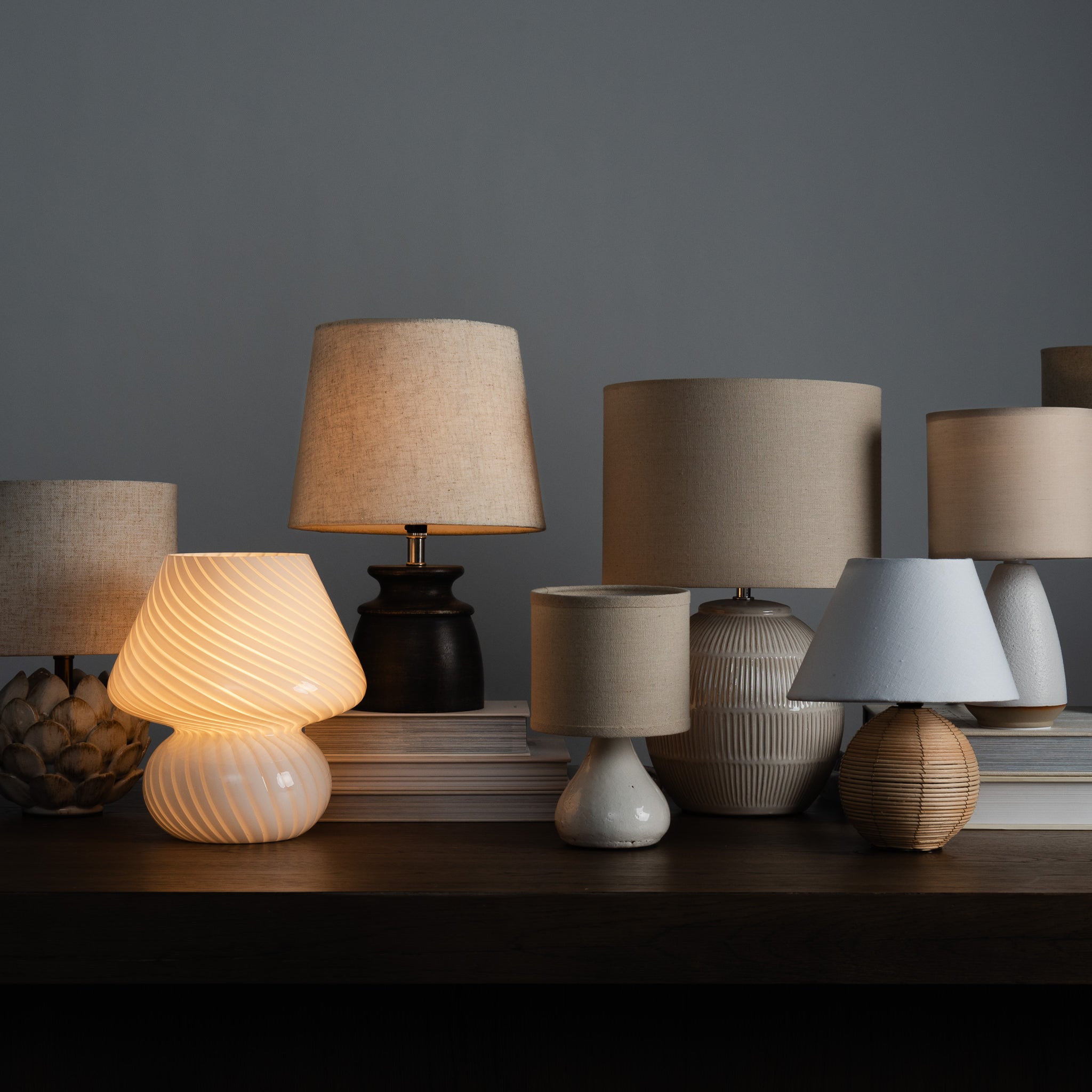Glassiest Lamp with a collection of mini lamps on a desk and a white background