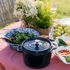 Golden Rabbit brand blue and white Cobalt Swirl Enamelware round serving bowl  on an outdoor table with salad in it
