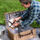Covington Classic Willow Four Person Picnic Basket on a picnic blanket with a model at Addison West