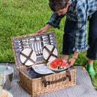 Covington Classic Willow Four Person Picnic Basket on a picnic blanket with a model at Addison West