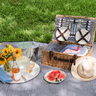 Covington Classic Willow Four Person Picnic Basket on a picnic blanket with a model at Addison West