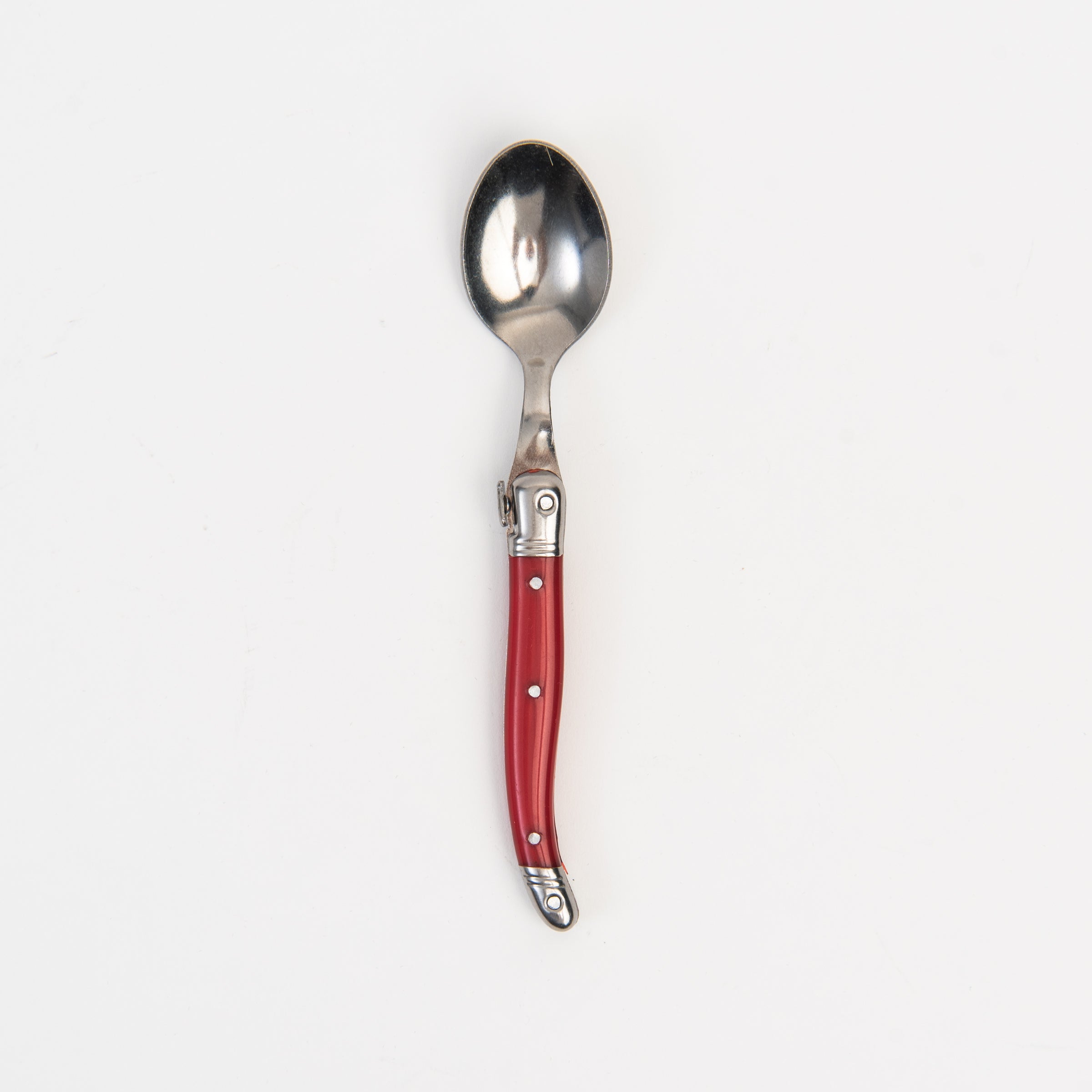 Laguiole Rainbow Spoon red on a white background at Addison West