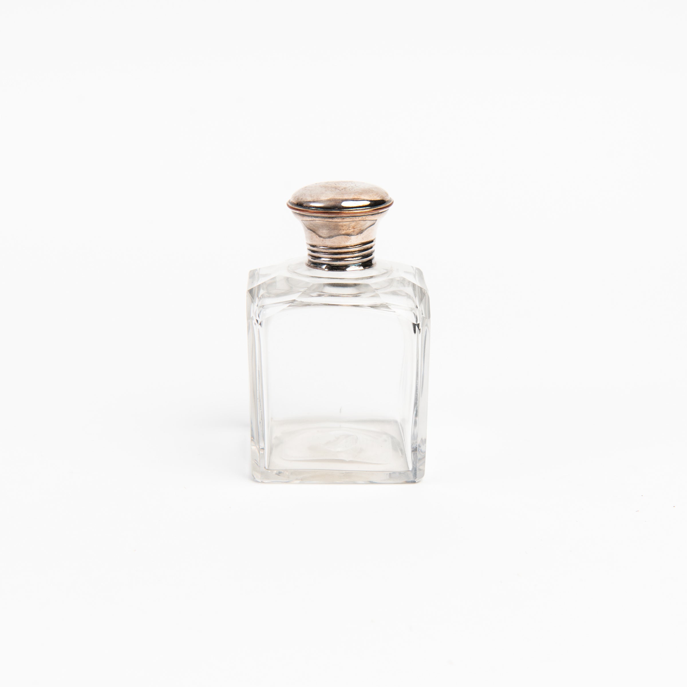 Vintage Glass Bottle With Silver Top on a white background at Addison West