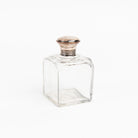 Vintage Glass Bottle With Silver Top on a white background at Addison West