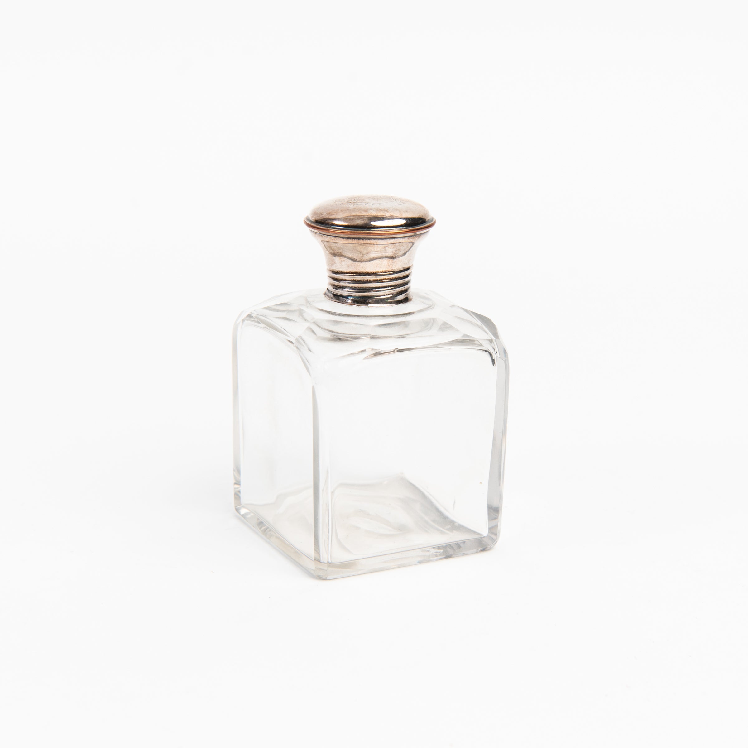 Vintage Glass Bottle With Silver Top on a white background at Addison West