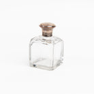 Vintage Glass Bottle With Silver Top on a white background at Addison West