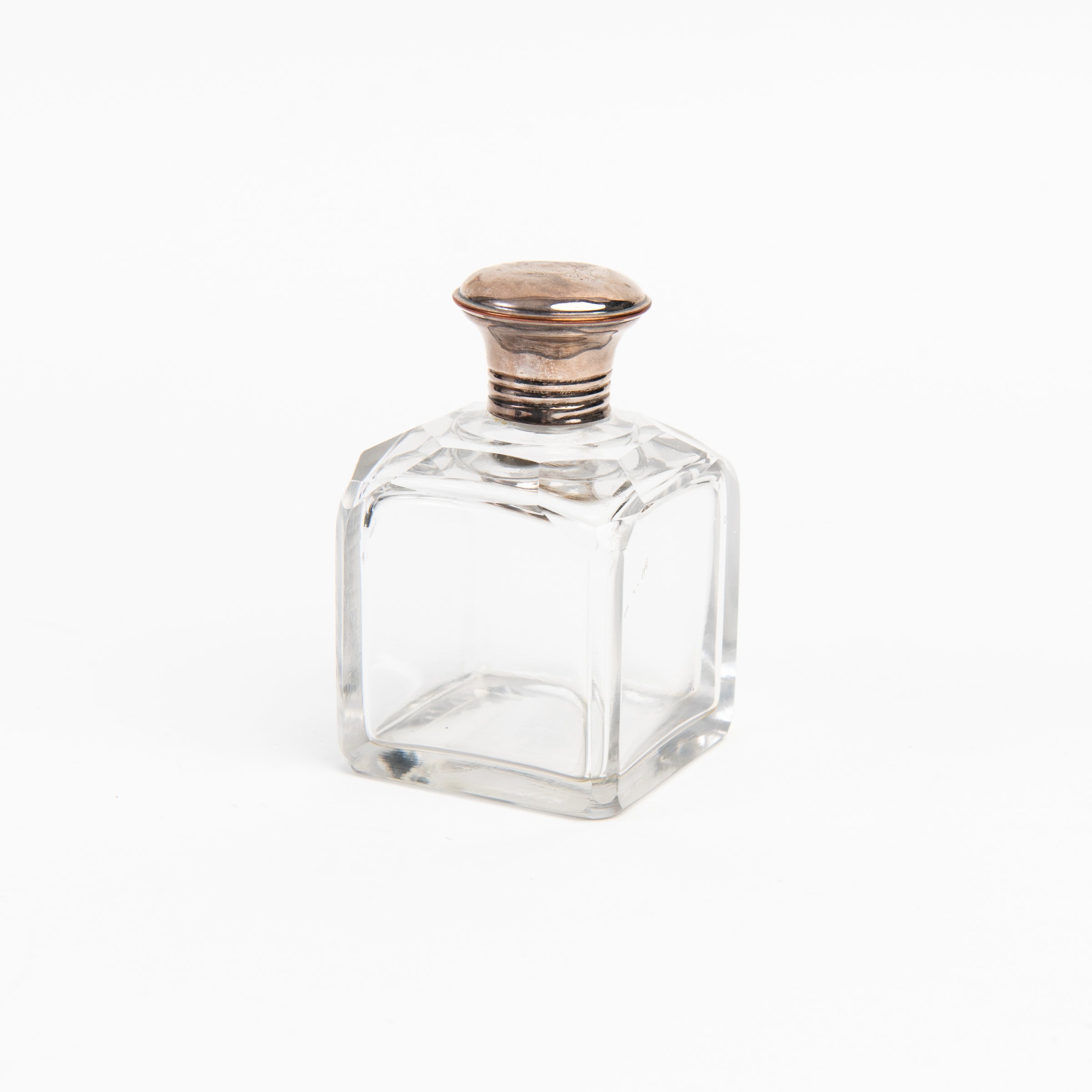 Vintage Glass Bottle With Silver Top on a white background at Addison West