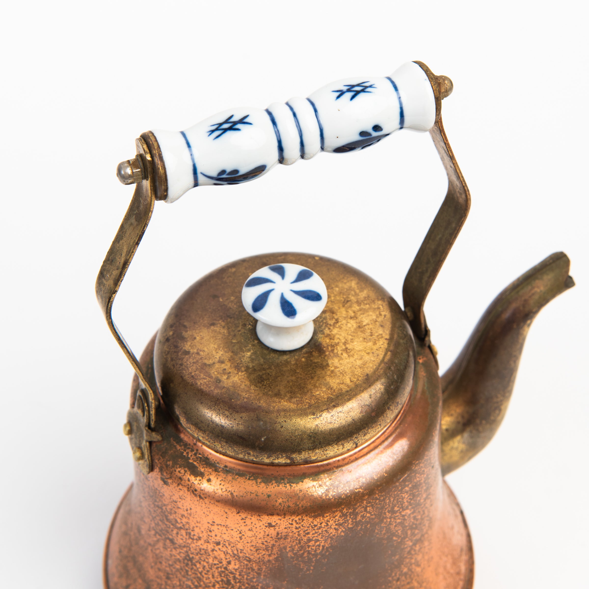 Close up of Vintage Copper Tea Pot with Delftware on a white background at Addison West