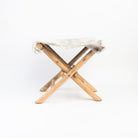 Teakwood and Goat Fur Folding Stool on a white background at Addison West