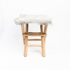 Teakwood and Goat Fur Folding Stool on a white background at Addison West