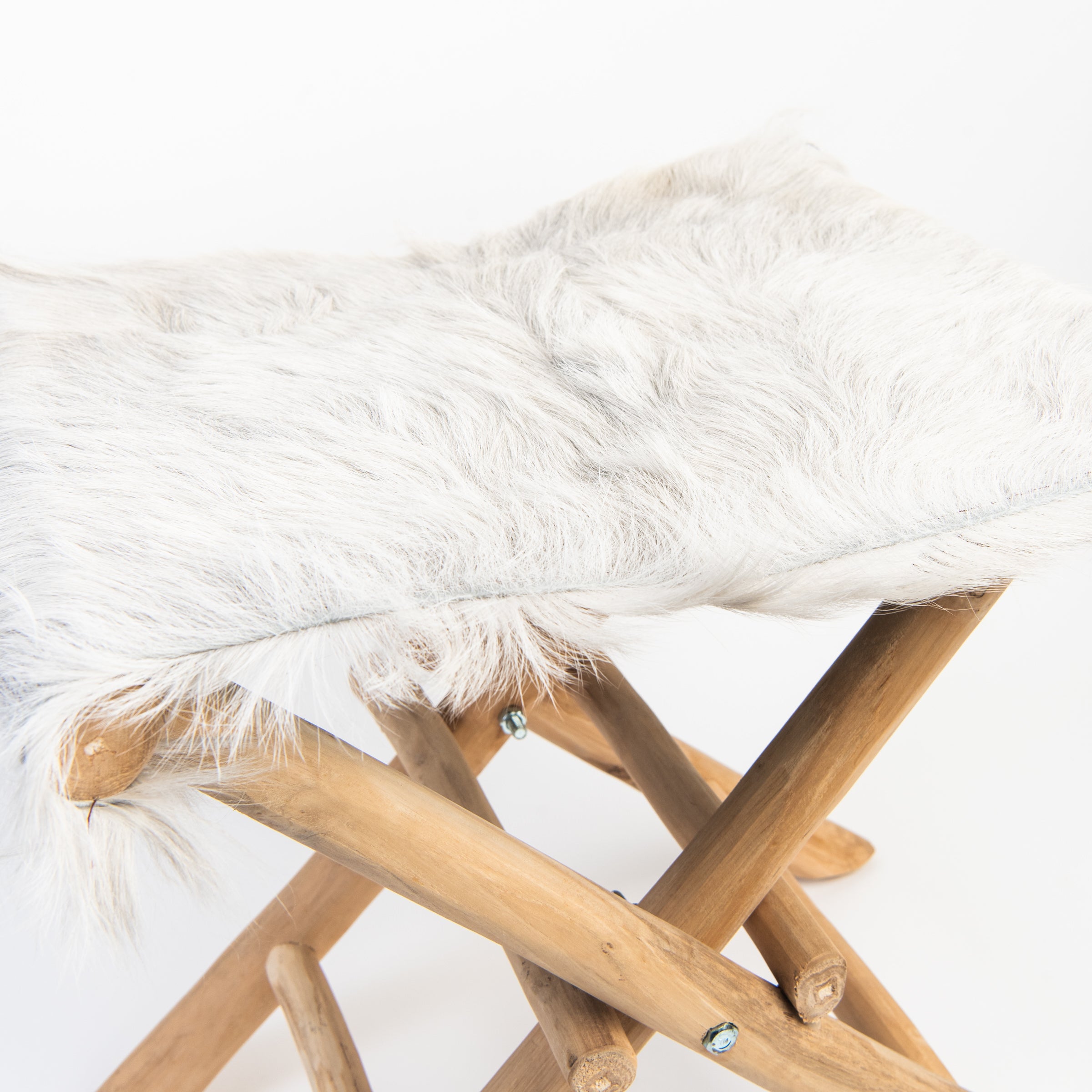 Teakwood and Goat Fur Folding Stool on a white background at Addison West