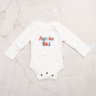 Apres Ski Baby Organic Cotton Bodysuit on a marble table at Addison West
