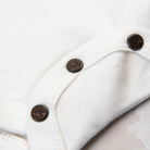 Apres Ski Baby Organic Cotton Bodysuit on a marble table at Addison West