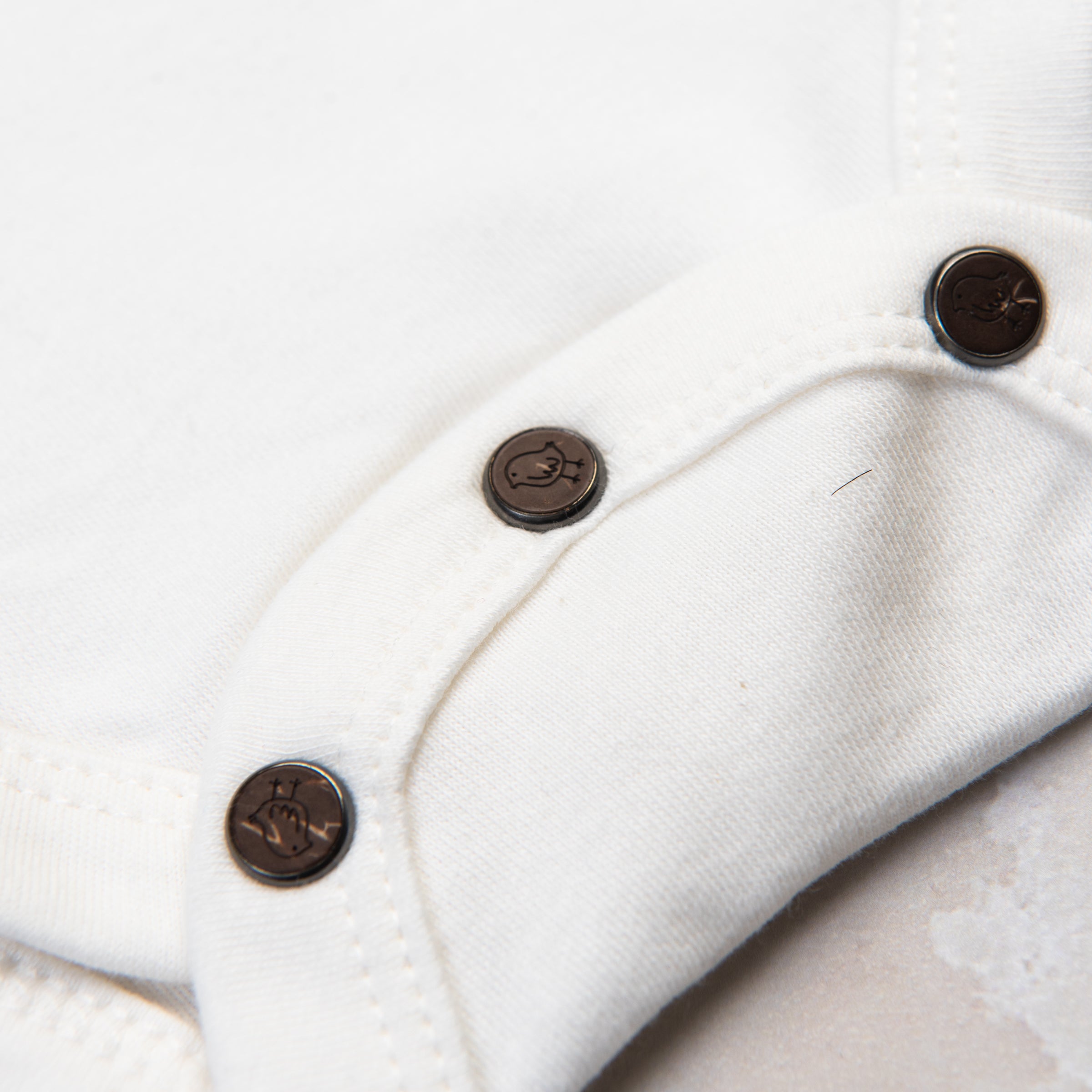 Apres Ski Baby Organic Cotton Bodysuit on a marble table at Addison West