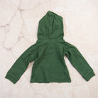 Organic Hoodie in Basil Green on a marble table at Addison West