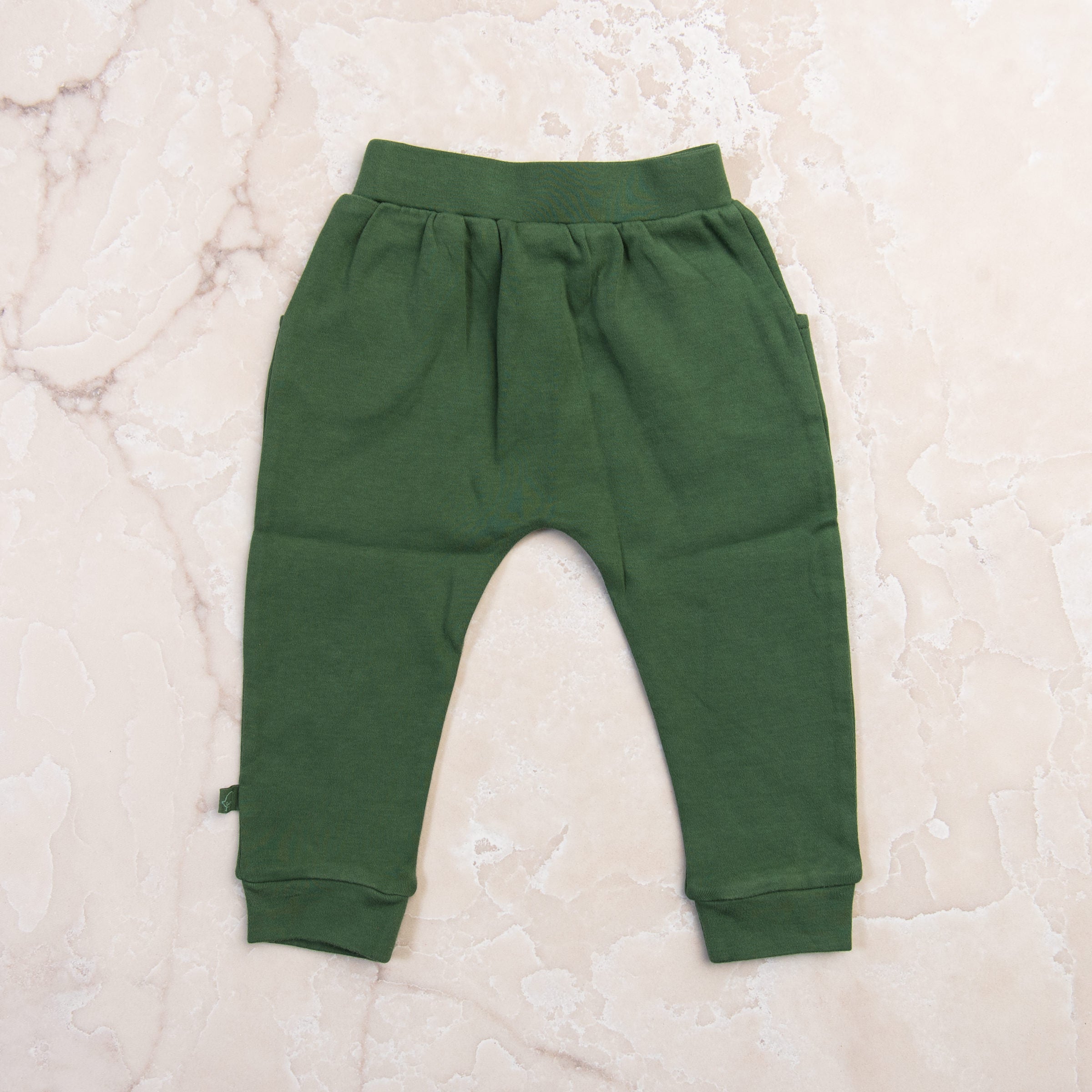 Organic Lounge Pants in Basil Green on a marble table at Addison West