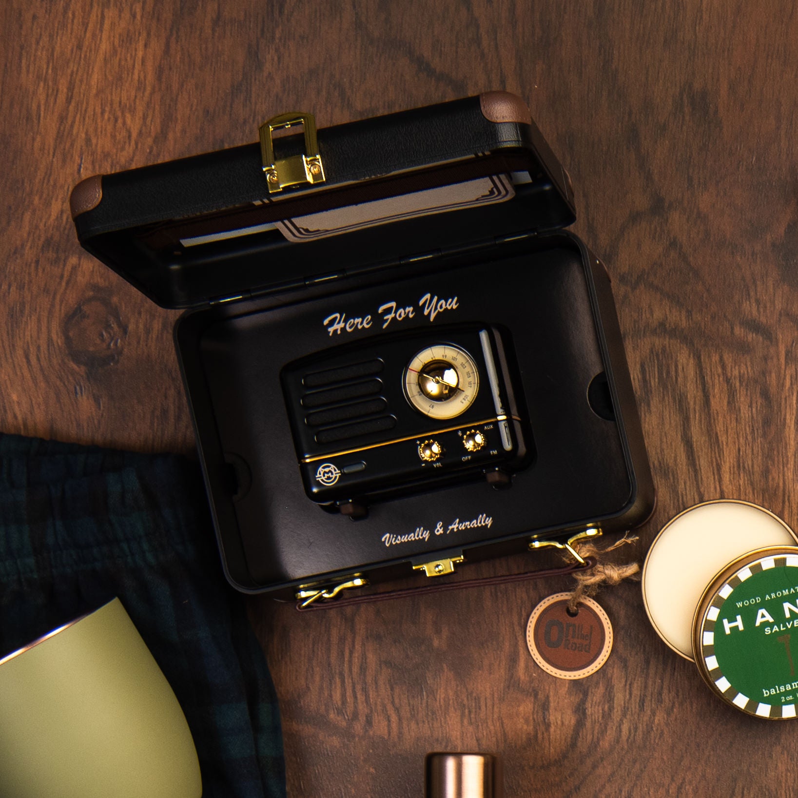 Muzen OTR Wireless FM and Bluetooth Speaker in Black on a wood table at Addison West