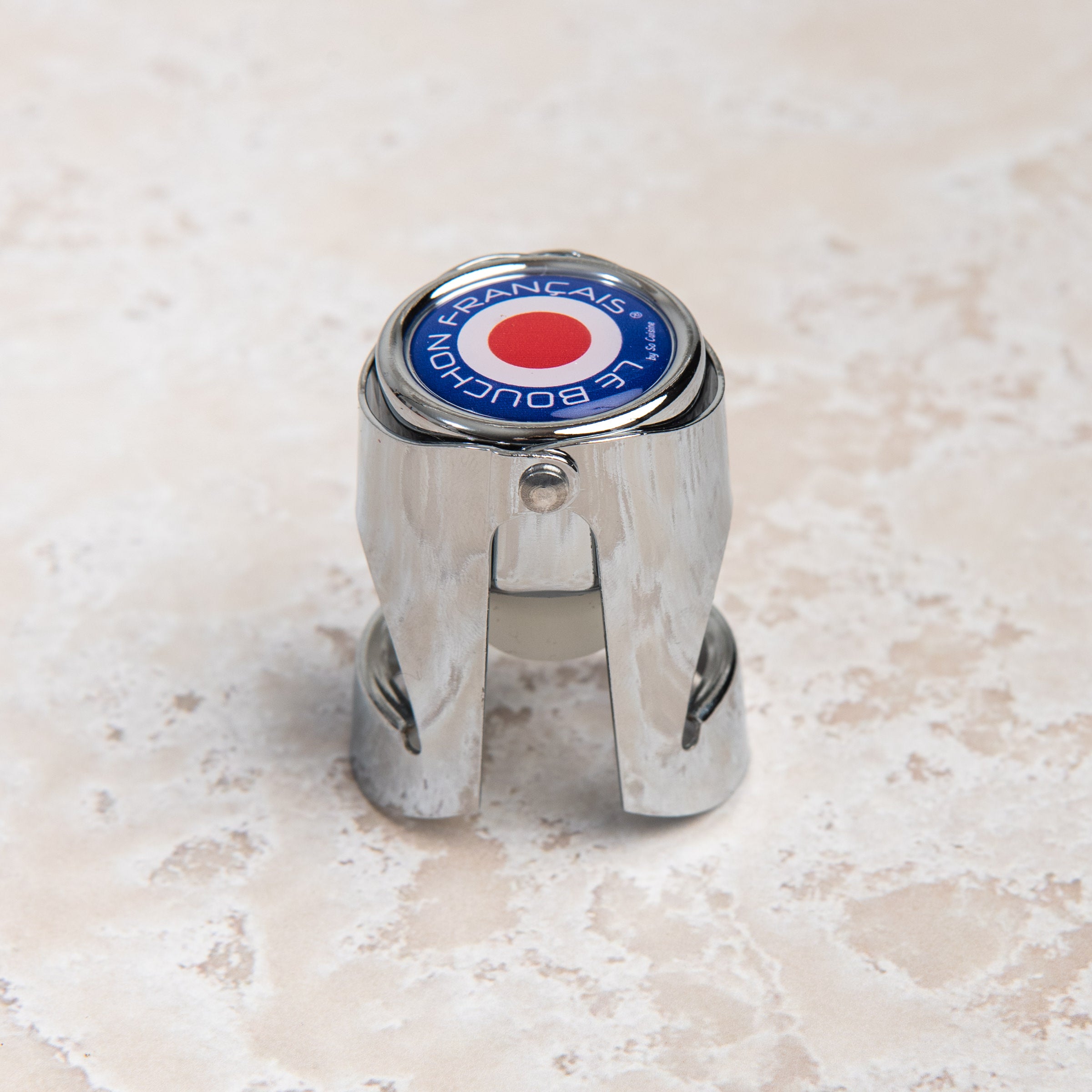 French Champagne Bottle Stopper on a beige background at Addison West