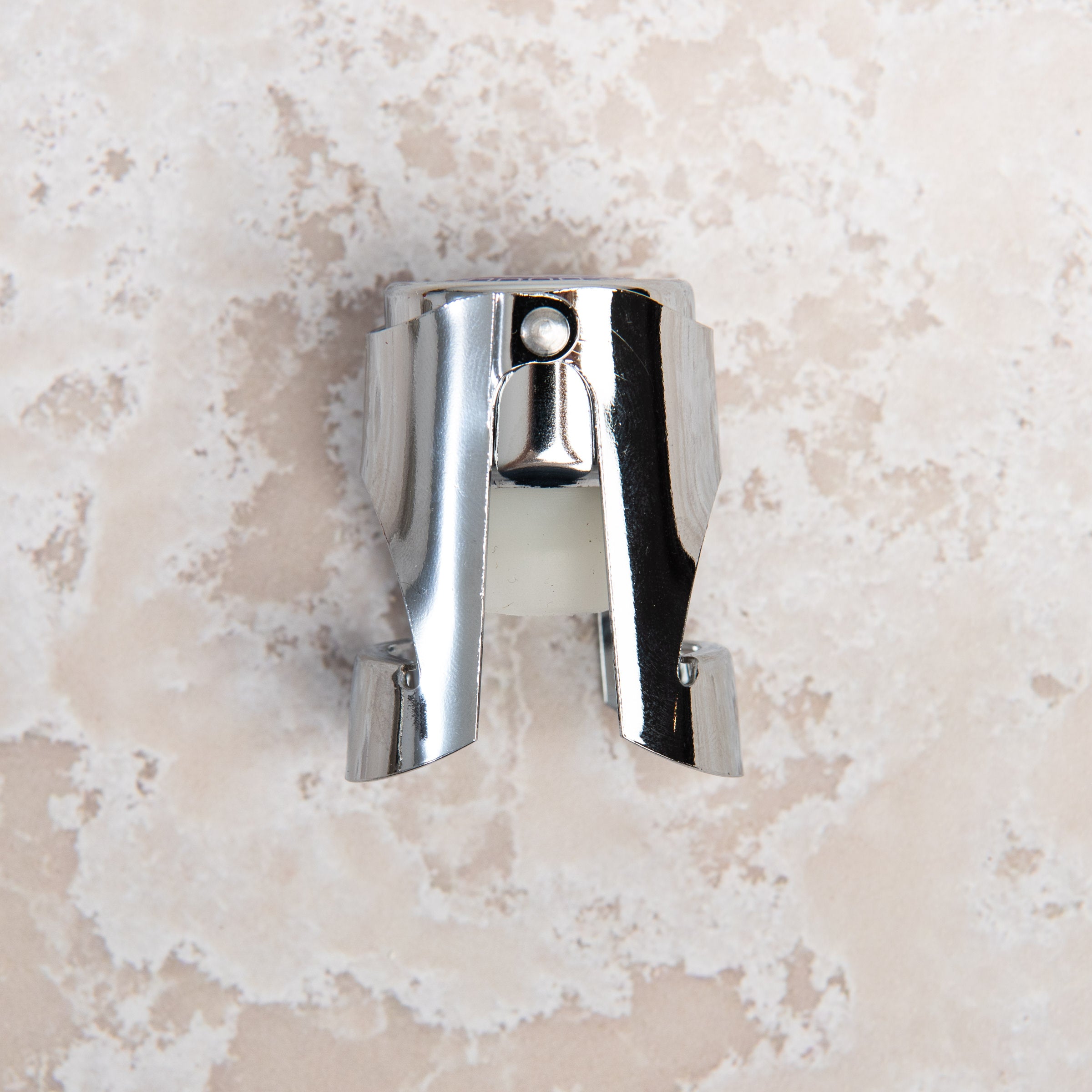 French Champagne Bottle Stopper on a beige background at Addison West