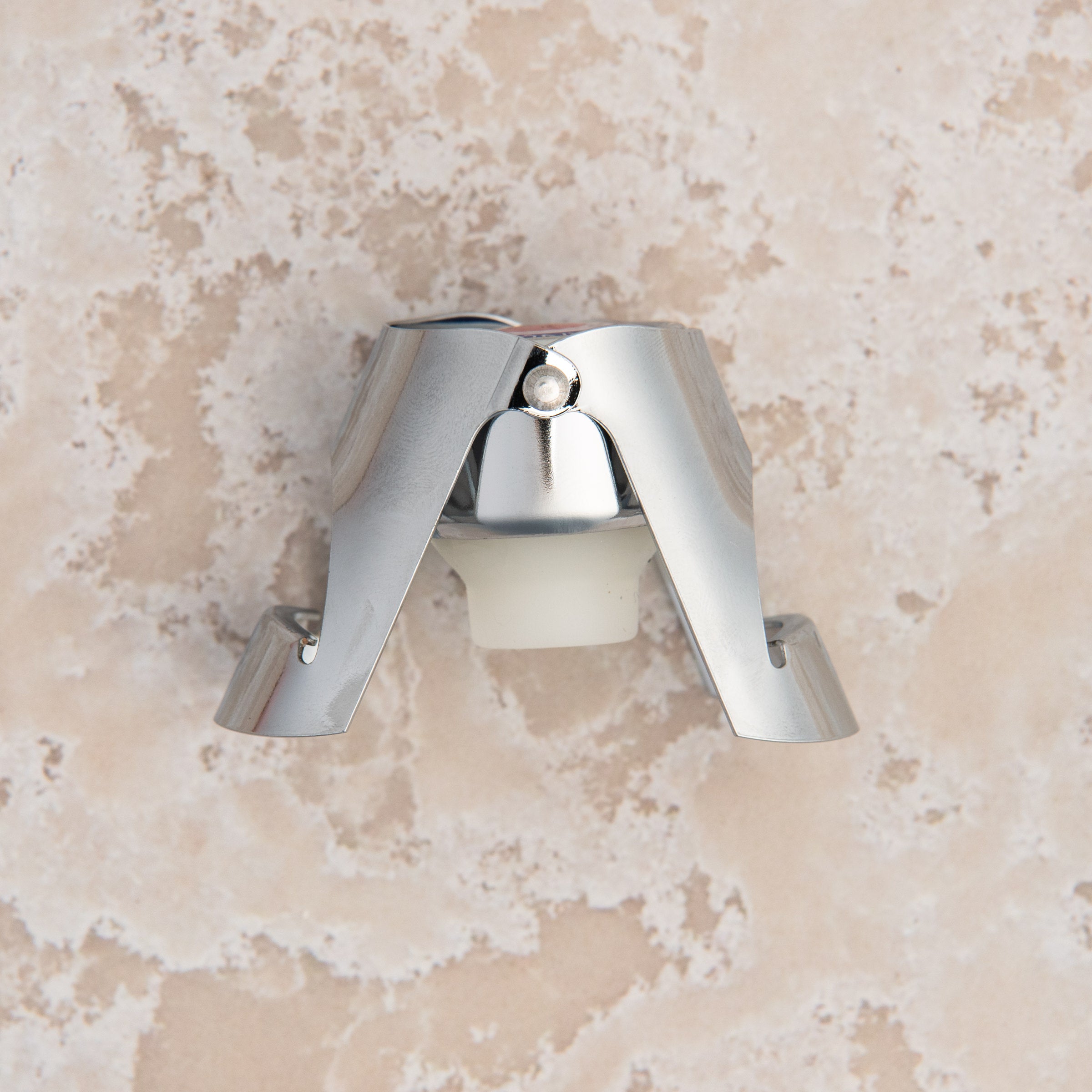 French Champagne Bottle Stopper on a beige background at Addison West