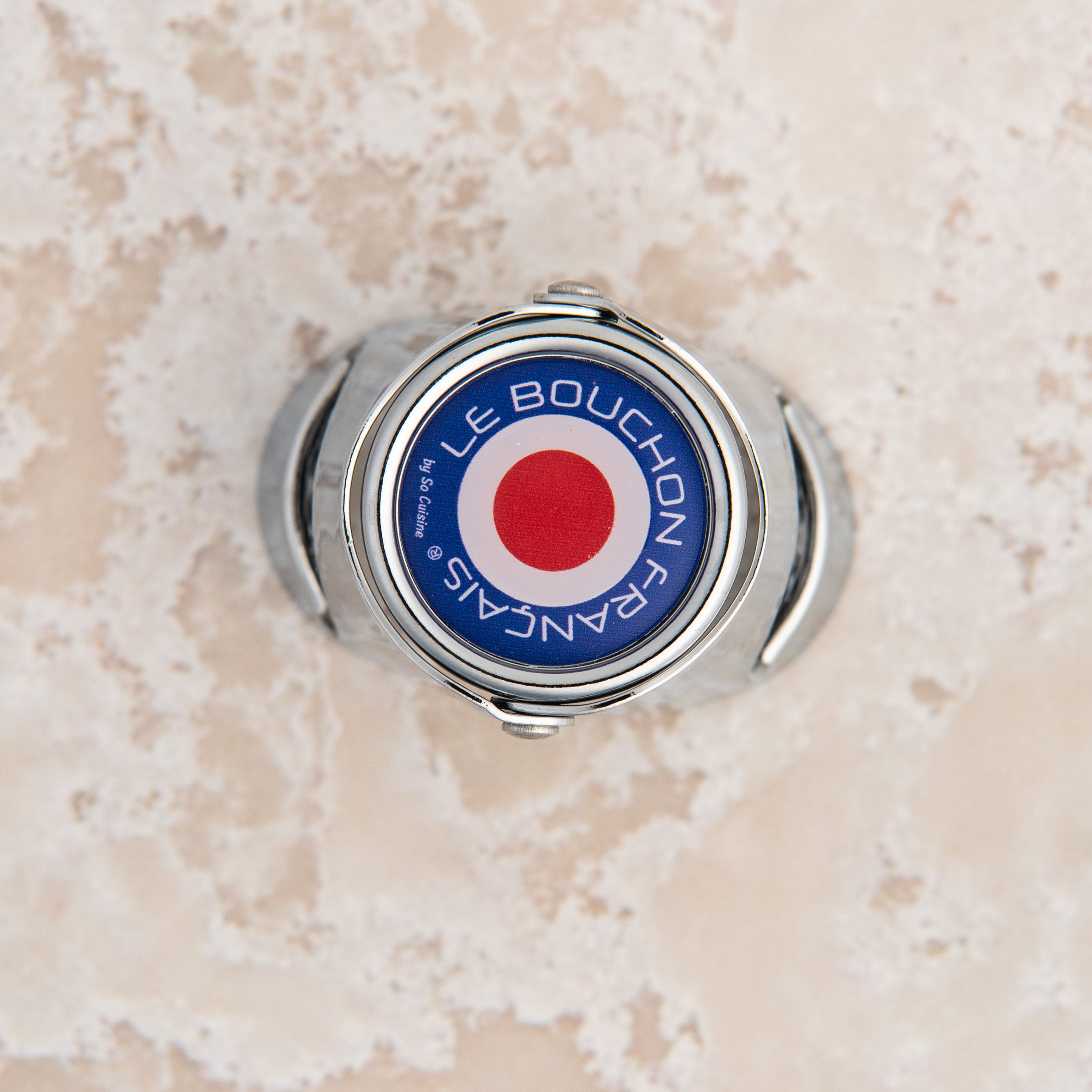 French Champagne Bottle Stopper on a beige background at Addison West