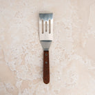 Brownie Spatula on a beige background at Addison West