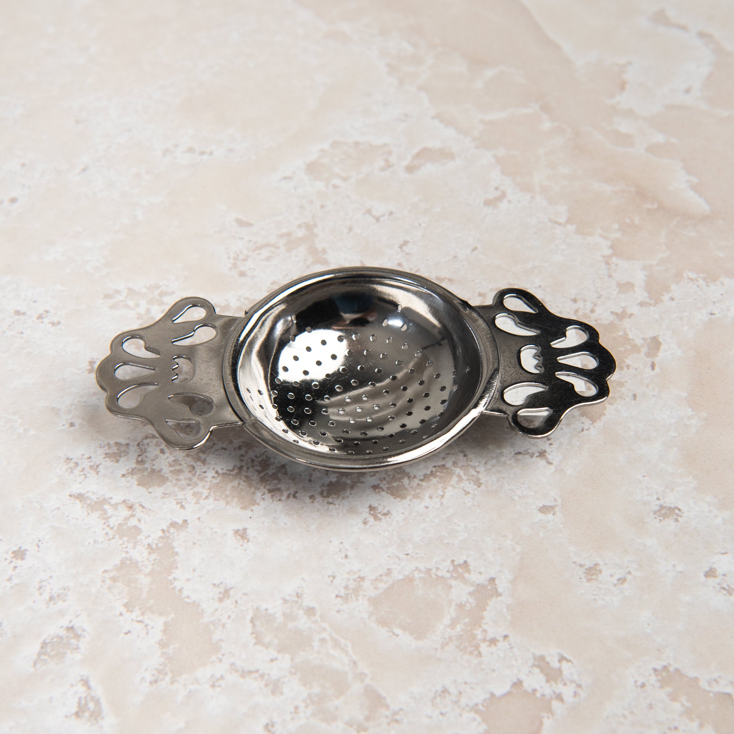 English Tea Strainer on a beige background at Addison West